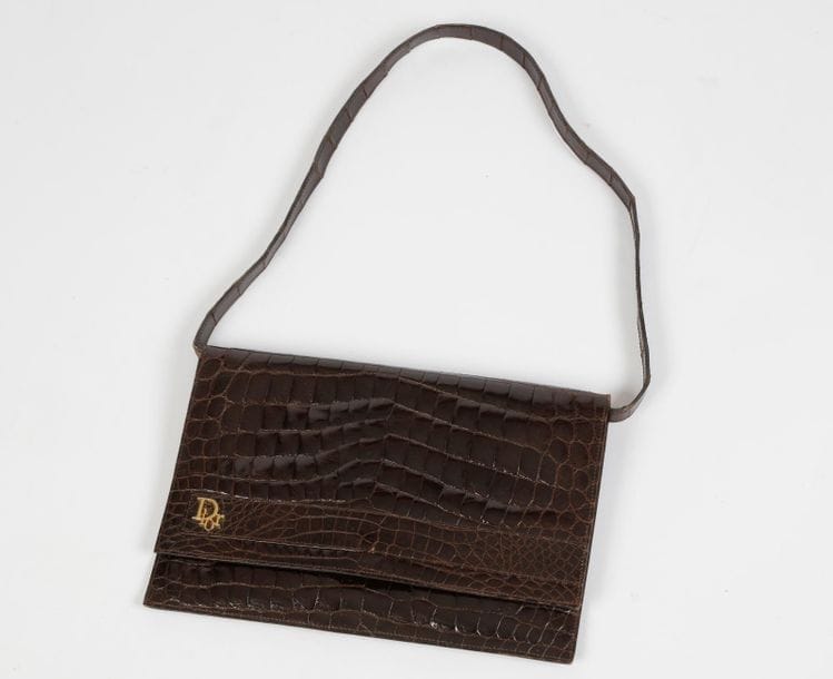 Christian DIOR, Made in France

Sac en cuir verni glacé marron, façon croco (transformable en pochette), rabat siglé DIOR.

Longueur : 29 cm

On y joint un portefeuille assorti non griffé (fermoir accidenté)



