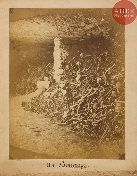 Félix Nadar (1820-1910)
Les catacombes de Paris, c. 1861-1864.
Crypte N°7.
Un bourrage.
Épreuve sur papier albuminé, contrecollée sur carton. Tampon-signature « Nadar » à l’encre rouge en bas à droite. Légendes manuscrites à l’encre sur le montage en bas.
23,3 x 18 cm

Bibliographie :
Philippe Néagu et divers, Le Paris souterrain de Félix Nadar 1861 : des os et des eaux, Paris, C.N.M.H.S., 1982, p. 34, ill. 42.
Sylvie Aubenas, Catacombes. Nadar au royaume des morts, L’Oeil Curieux, Paris, 2018, p. 10.

« Par la main des manœuvres spéciaux attachés à l’année à ce service, les côtes, vertèbres, sternums, carpes, tarses, métacarpes et métatarses, phalanges, etc., tout le menu des os, sont refoulés, tassés en masses plus ou moins cubiques sous les cryptes, — en bourrages, comme on dit ici, — et maintenus à l’avant par des têtes choisies dans les mieux conservées : — ce que nous appelons les façades ».
Félix Nadar, Quand j’étais photographe, Paris, Flammarion, 1899.