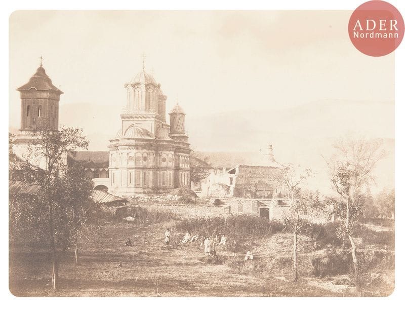 Photographe non identifié
Album de la Valachie, dédié à S. A. S. le prince B. D. Stirbey.
[Roumanie], c. 1855-1860.
Curtea de Arges et son monastère. Monastère de Bistrita (Valcea). Le monastère de Tismana. Église du monastère de Stavropoleos (Bucarest). Gorges. Cascades.
Album in-folio en plein maroquin rouge, titré en lettres dorées sur le premier plat, composé de 24 épreuves sur papier salé contrecollées sur cartons et séparées par des serpentes. Nombreuses retouches à l’aquarelle et à la gouache blanche sur les épreuves.
Format moyen des épreuves : 32 x 22,5 cm

Provenance :
Galerie Texbraun, Paris.
