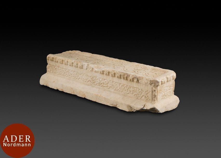 Cénotaphe en marbre, Asie Centrale, daté 892 ou 893H. / 1487 ou 1488
Cénotaphe rectangulaire à décor sculpté en creux sur le dessus d’une frise florale encadrée de palmettes et à bordure en zigzags. Faces latérales sculptées de cartouches inscrits de vers  en calligraphie naskhi réunis par un médaillon quadrilobé à décor floral sur les grands côtés. Un des petits côtés flanqué de colonnettes indique la date de Jumada I 892 ou 893H./avril-mai 1487 ou 1488, le second est lisse et sans décor. Une corniche de muqarnas court sur tout le pourtour de la stèle qui repose sur une base aux côtés inclinés fragmentaire. 
Dim. : 86 x 25 x 21 cm 
Etat : manques (une des colonnettes, sur la frise de stalactites, une extrémité).
Provenance : collection française depuis 1980. 

A marble funerary stele, Central Asia, dated 892 or 893H. / 1487 or 1488
