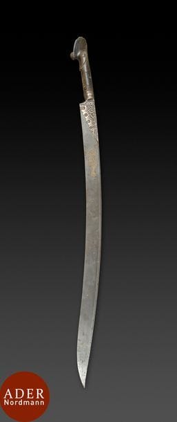 Sabre ottoman, yatagan, Turquie, daté 1311H. / 1893
Lame courbe en acier à un tranchant damasquiné à l’or d’un cartouche hexagonal à appendice fleuronné calligraphié d’une formule de vœux et daté 1311H. / 1893, talon gravé de rinceaux végétaux, monture en corne.
L. : 91 cm
État : quelques taches d’oxydation sur la lame.

An Ottoman sabre, yatagan, Turkey, dated 1252H. / 1836