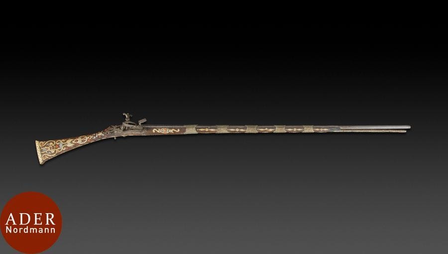 Fusil à silex, mukhala, Algérie, XIXe siècle
Fusil en bois incrusté de plaquettes d’os et de nacre rehaussées de polychromie rouge : composition d’arabesques sur la crosse, rosettes, croissants de lune, étoiles à cinq branches et autres garnitures sur la culasse et sur le canon bagué de métal argenté à décor repoussé. 
Long. : 173 cm
État : accidents, sauts d’incrustations, restauration.

A flintlock pistol, mukhala, Algeria, 19th century 