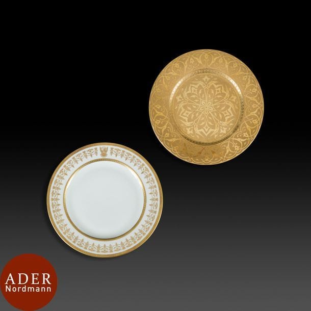 Deux assiettes en porcelaine blanche dorée, France, Limoges, XXe siècle
- L’une pour la République Démocratique du Soudan avec la marque « Bernardaux ». Peinte sur le marli d’une guirlande végétale dorée interrompue par un motif d’aigle aux ailes déployées encadré de deux rubans inscrits en arabe : « ansiran – jumhuriyya as-Sudan ad-dimikratiyya »
 « Supporters de la République Démocratique du Soudan ». Diam : 24,5 cm, État : très bon état. - L’autre pour le Sultanat d’Oman avec la marque « Old Abbey ». Entièrement dorée et ornée d’une composition végétale rayonnante au centre, d’une frise de palmettes sur le cavet et de rinceaux à palmettes et fleurons sur le marli. Avec son écrin en cuir vert et velours orné à deux reprises de l’emblème du Sultanat d’Oman. Diam : 24,5 cm, État : assiette légèrement rayée, un trou dans le cuir de l’écrin.

Two porcelain plates, France, Limoges, 20th century