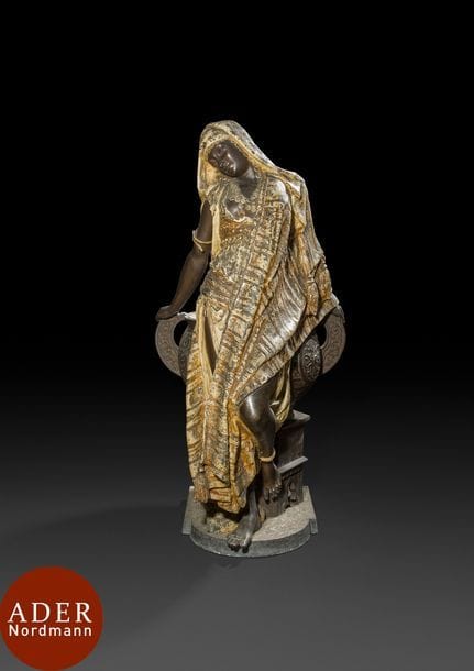 Importante jardinière en bronze soutenue par une femme orientaliste, Europe, XIXe siècle
Jardinière en bronze constituée d’une cuve à deux anses, ornée de rondeaux à palmettes posée sur un guéridon hexagonal aux pieds arqués et orné de frises végétales et pseudo-inscriptions sur le rebord. Soutenue par une femme en ronde bosse. Signature illisible sur la base.
Dim. : 83 x 44,5 x 27,5 cm
État : sauts de polychromie, accidents

A bronze orientalist jardinière, Europe, 19th century