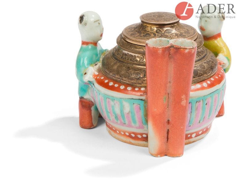 CHINE - Fin XIXe siècle
Rince-pinceaux en porcelaine émaillée polychrome monté en encrier en argent, deux enfants accolés au pot.
H. : 5,5 cm ; monture en bronze. (État non garanti sous la monture).