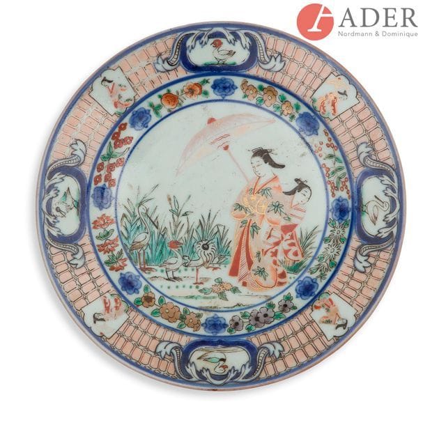 JAPON, Imari - XVIIIe siècle
Assiette en porcelaine émaillée or et polychrome en bleu sous couverte, vert, noir, et rouge de fer, de deux femmes au parasol en compagnie d’échassiers parmi les roseaux à décor central d’après un dessin de Cornelis Pronk (Amsterdam, 1691-1759).
Diam. : 23 cm