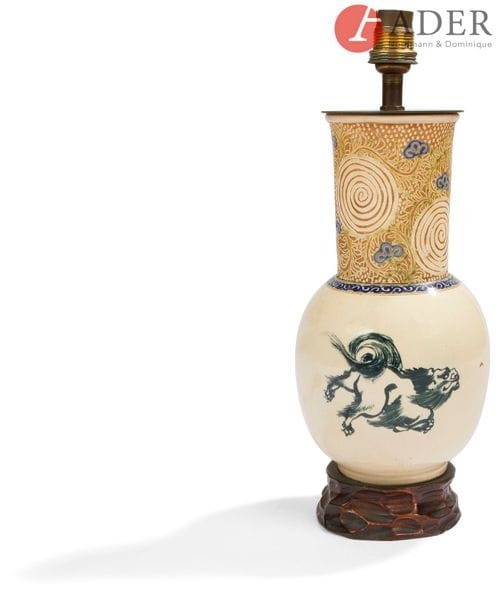 JAPON, Fours de Satsuma - XXe siècle
Vase en faïence de Satsuma à panse basse et col long, à décor émaillé de shishi courant, le col orné de rinceaux fleuris et cercles concentriques. Monté en lampe.
H. : 22,5 cm