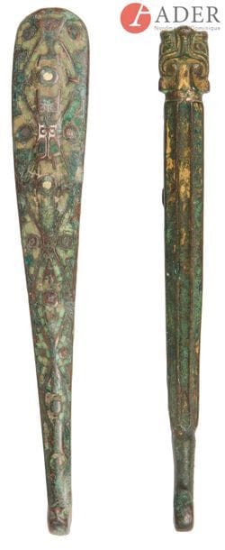CHINE - Époque HAN (206 av. JC - 220 ap. JC)
Deux fibules en bronze à trace de dorure, la tête de l’une forme taotie. 
L. : 17,5 et 18,3 cm