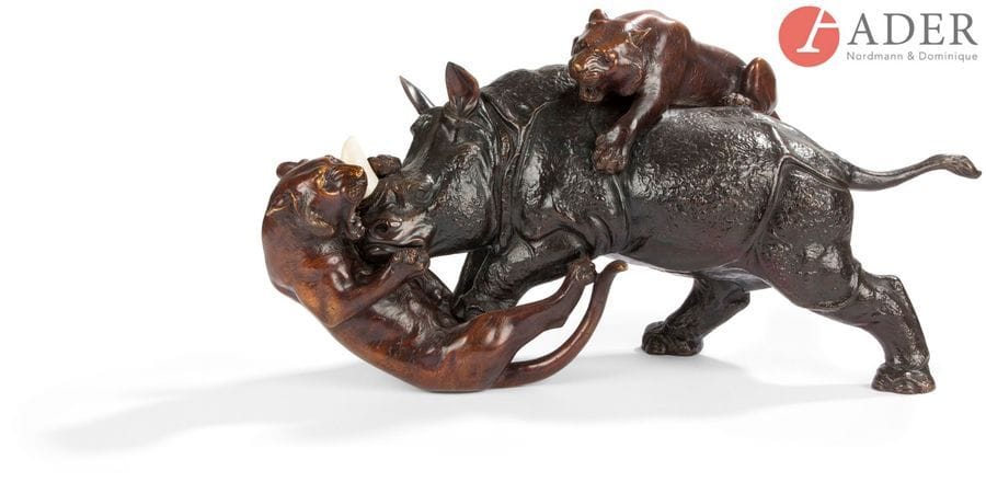 JAPON - Époque MEIJI (1868 - 1912)
Groupe en bronze à patine brune, rhinocéros debout surmonté par deux tigres l’attaquant, la corne du rhinocéros en ivoire. Signé de manière illisible. Dim. : 29 x 57 cm