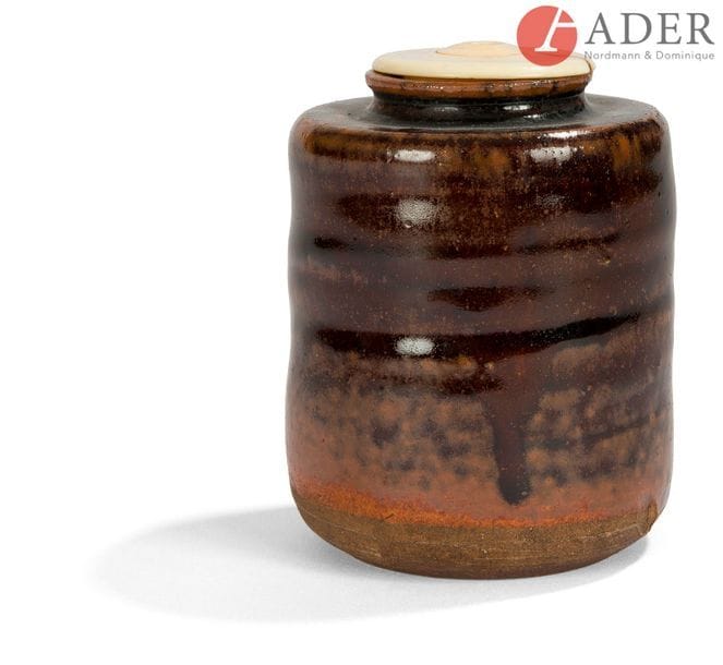 JAPON - XIXe siècle
Chaïre cylindrique légèrement balustre en grès brun émaillé brun roux.
H. : 7,8 cm ; bouchon en ivoire.