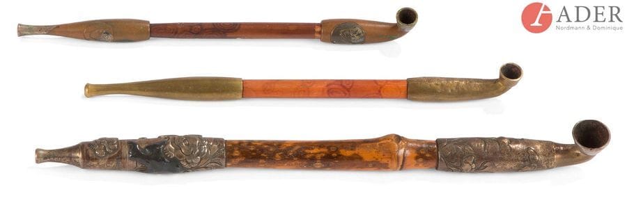 JAPON - Époque MEIJI (1868 - 1912)
Trois kizeru (pipes) en bambou, les embouts en shubuichi, suaka et laiton à décor de shishi dans les pivoines et poupées daruma.
L. : 20 ; 20,5 et 26 cm