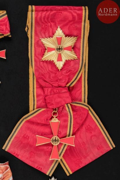 ALLEMAGNE - RÉPUBLIQUE FÉDÉRALE
ORDRE DU MÉRITE FÉDÉRAL, créé en 1951.
Ensemble de grand-croix de Seyid Hassan Taghizadeh, Président du Sénat impérial d’Iran, comprenant :
- Bijou, en bronze doré et émail. Avec son écharpe brodée d’aigles.
80?x?68?mm
- Plaque, en vermeil et émail. Revers à attache basculante. Poinçon de titre 935 et d’orfèvre SK.
80?mm - Poids brut : 49?g
- Insigne de boutonnière de grand-croix.
Dans son écrin gainé de velours bleu nuit, frappé de l’Aigle fédéral, de la Maison SHULER & KUN.
Avec reproductions de son brevet de grand-croix et de sa biographie (en langue anglaise).
SUP. 