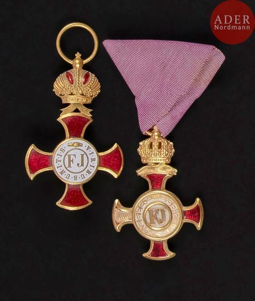 AUTRICHE
CROIX DU MÉRITE CIVIL «?Zivil Verdienstkreuz?», créé en 1850.
Croix d’or avec couronne.
En or et émail (manque à deux branches).
Ruban triangulaire mauve, anneau poinçonné d’un orfèvre viennois (en partie illisible). Dans son écrin marqué F.J.V.
52?x?31?mm - Poids brut : 14?g
On y joint une deuxième croix du mérite «?or avec couronne?» fabrication de guerre uniface en bronze doré. 62?x?33?mm
T.B.