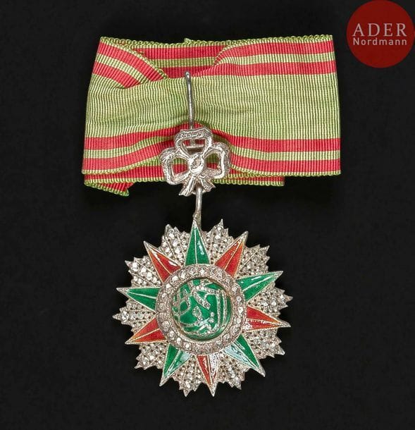 FRANCE - TUNISIE
ORDRE DU NICHAN IFTIKHAR, créé en 1835.
Étoile d’officier montée en commandeur au monogramme de Mohamed Es Sadok Bey (1859-1889). En argent et émail (petits éclats), fragment de cravate. Poinçon tunisien.
74?x?48?mm - Poids brut : 39?g
T.T.B.