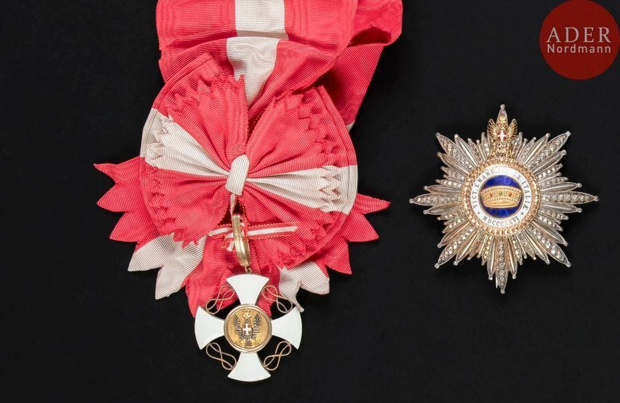 ITALIE
ORDRE DE LA COURONNE D’ITALIE, créé en 1868.
Ensemble de grand-croix :
- bijou, en or et émail (infimes cheveux). Avec son écharpe.
53?x?50?mm - Poids brut : 15?g
- plaque en argent travaillé à pointes de diamant, centre en or ciselé et émail.
Revers à deux crochets et attache basculante. Poinçons au cygne et au hibou. Marque du fabricant Cravanzola.
86?mm - Poids brut : 74?g
T.T.B. 