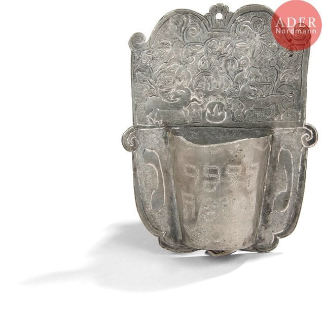 [YAHR-ZEIT] LAMPE MÉMORIELLE 
Allemagne, XVIIIe siècle. 
Étain gravé. 
Hauteur : 15,5 cm 
Coupe conique coupée en deux et soudée à une plaque. La plaque est gravée d’une couronne supportée par deux animaux unicornes et d’un décor de fleurs et de feuillage. De chaque côté de la demi-coupe est gravée une lettre en hébreu. Les deux lettres forment ensemble l’abréviation de l’expression : Lumière de l’âme La demi-coupe est gravée de l’inscription hébraïque : En mémoire de l’âme.
Provenance : 
Collection Schenker, Vente Ader du 22 avril 2015, Lot n° 184



Mots clés : {CR}judaïca, juif, juive, hébreux, rabbins, jewish, torah, hebrew, hebraica,, judaisme, synagogue, sionisme, pessah, pessach, haggada, haggadah, hagada, hagadah, passover, menora, menorah, hannuka, hannuca, hannoucca, hanouccah, torah, juden, israélite, Israël, antisemitism, antisémitisme, dreyfus, meguila, sepharade, sefarad, ketouba