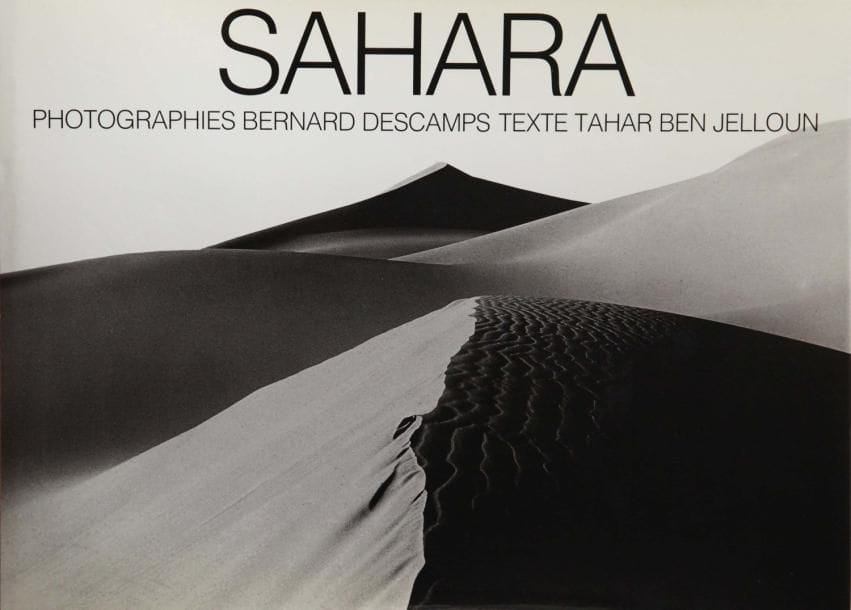 Bernard Descamps - Tahar Ben Jelloun
Sahara Editions AMC, Mulhouse, 1987. In-4 à l'italienne (25 x 32 cm). Edition originale signée et dédicacée par le photographe. 115 pp. Reliure d'éditeur sous jaquette illustrée.  