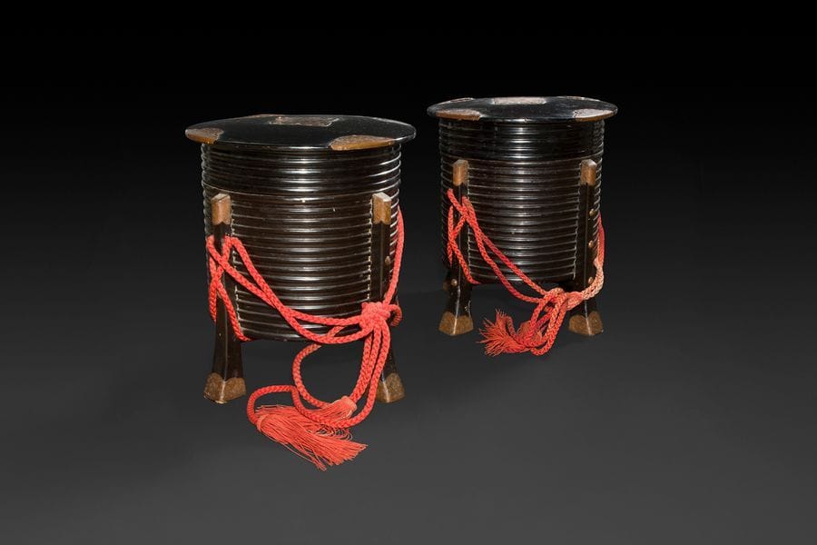 JAPON - Époque MEIJI (1868 - 1912)
Deux hokki quadripodes en laque noir orné de plaques de laitons. (Accidents et manques). 
H : 40, 5 cm