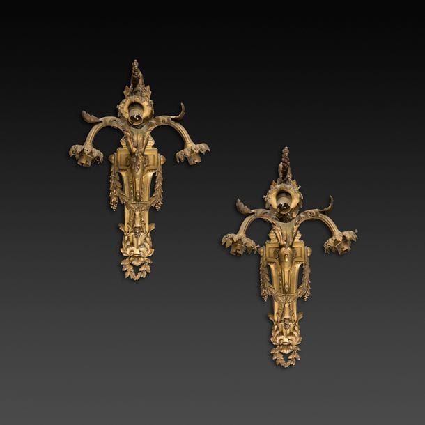 Paire d’appliques en bronze doré à trois lumières, le fût à cannelures et décor de feuillages.
Fin du XIXe siècle.
H : 55 cm, L : 27 cm