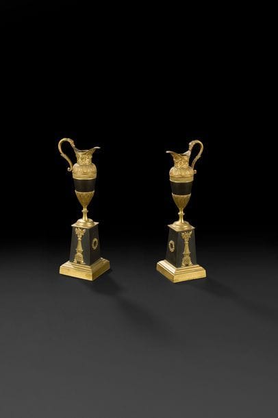 Paire d’aiguières d’ornement en bronze patiné et doré, reposant sur des socles en gaine.
XIXe siècle.
H : 28 cm