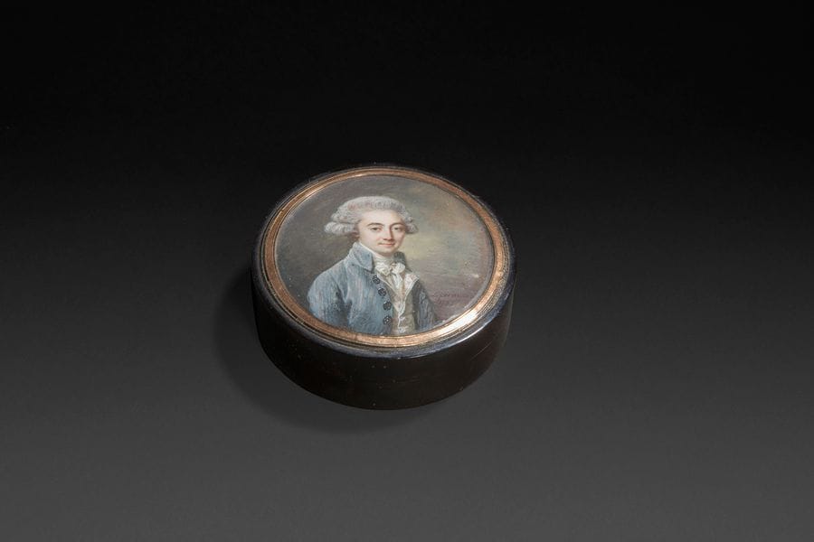 Louis-Lié PERIN (Reims, 1753-1817).
Homme en costume gris rayé rose, et gilet brodé, cravate blanche gansée jaune, perruque poudrée, à mi-corps de trois-quarts à droite
Miniature sur ivoire de la fin du XVIIIe siècle, à vue diam. 6,3 cm
Signée et datée en bas à droite : L. perin / 1788
Sur le couvercle d’une boite en écaille noire légèrement mouchetée du XVIIIe siècle, diam. 7,8 cm
Quelques petites moisissures sous le verre sinon bon état. 

Périn exposa des miniatures aux Salon de 1793, 1795, 1798 et compta parmi les meilleurs artistes de son temps. Il est représenté dans les principales collections de miniatures.