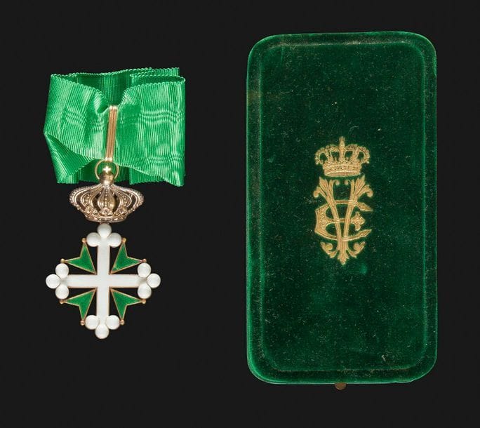 ITALIE 
ORDRE DE SAINT MAURICE ET LAZARE, créé en 1572. 
Croix de commandeur. 
En or (couronne ternie) et émail (éclats à l’émail blanc, léger éclat à l’émail vert). Cravate. 
83 x 51 mm - Poids brut : 27,3 g 
Dans son écrin recouvert de velours vert, marqué à l’or du chiffre du Roi Victor Emmanuel, avec marque du fabricant Cravanzola à Rome dans le couvercle. 
T.B.