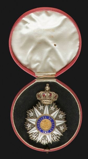 PORTUGAL 
ORDRE DE NOTRE DAME DE VILLA VICOSA, créé en 1819. 
Plaque de grand-croix. 
En vermeil et émail. Couronne à intérieur émaillé rouge. Centre en or, en trois parties, et émail. Revers à deux crochets et attache basculante. Marque du fabricant « Mon PAUL STOPIN – A. PETITDUBOSQ SUCCESSEUR – 231 PALAIS ROYAL ». Poinçon tête de sanglier.
Dans un écrin rond recouvert de papier façon maroquin rouge et garni de soie noire et ivoire.
90 x 64 mm - Poids brut : 70,5 g 
SUP. Belle qualité.
