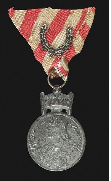 CROATIE 
ORDRE DE LA COURONNE DU ROI ZVONIMIR, créé en 1941. 
« Médaille de fer » en zinc. Ruban triangulaire avec feuilles de chêne émaillées. 
42 x 31 mm 
SUP.