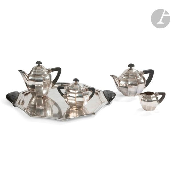 GALLIA - CHRISTOFLE CIRCA 1924 - 1925
Thé café en métal Gallia composé de quatre pièces et son plateau, modèle à côtes creuses, les anses et prises en palissandre. Bon état d’argenture. Numéro de modèle : 5891.

Ce lot a été décrit par Mme Claire Badillet (membre CNES), expert en argenterie ancienne et moderne. 