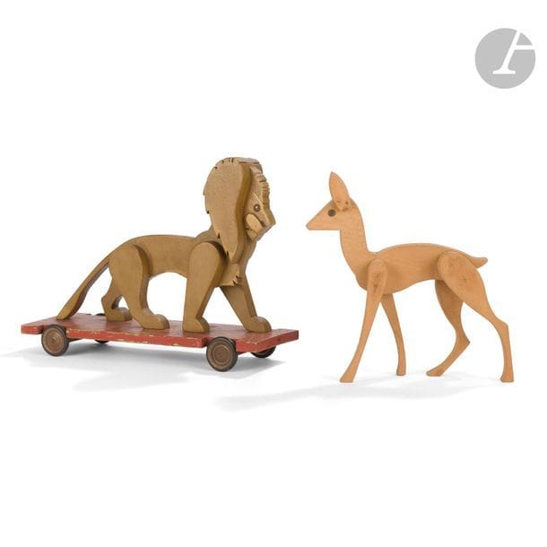 LUCIEN VIROT (1909-2003) & L.V. FABRICANT
Lion 
Jouet à tirer en bois laqué polychrome, les quatre roulettes et les yeux en métal. Manque la cordelette. Porte un tampon Modèle déposé et une étiquette du fabricant sous la planche. 32 x 43,5 x 15 cm 
On y joint : 
LUCIEN VIROT (1909-2003) 
Biche 
Jouet en bois naturel, yeux en métal. 30 x 27 x 7 cm
