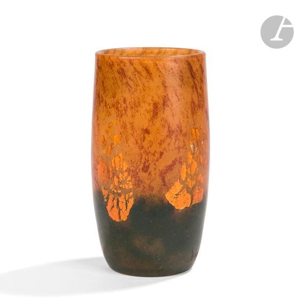 DAUM NANCY 
Vase gobelet légèrement fuselé. Épreuve en verre ocre et traité vert sombre à la base, le décor de salissures intercalaires brunes et de feuilles de cuivre éclatées. Signé DAUM Nancy à la Croix de Lorraine vers la base. H. 12 cm 