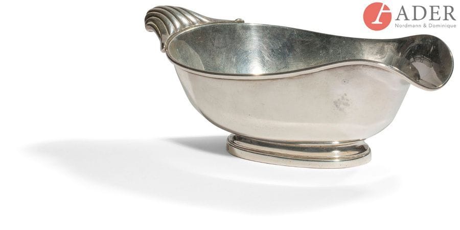 TéTARD Frères orfèvre et en toutes lettres 
Saucière en argent de forme ovale à un bec verseur, elle repose sur une bâte à ressaut, le corps est lisse bordé de filets, la prise figurant une coquille.
Poinçon minerve
Poids : 150,90 g - longueur : 15,8 cm
largeur : 9,3 cm - hauteur : 5,5 cm
