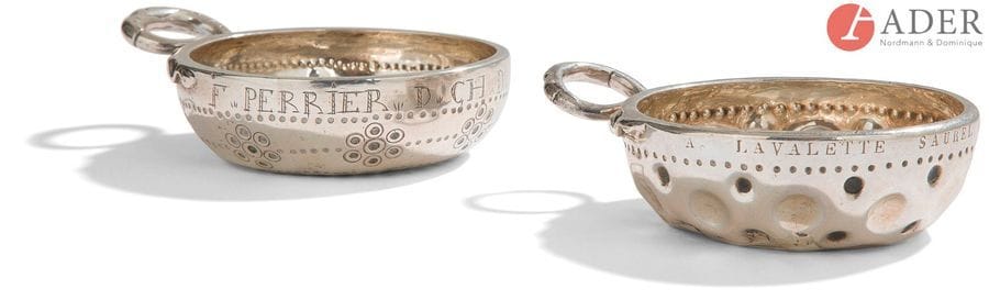 DEUX TASSES à VIN ATTRIBUéES AU PUY-DE-DôME 
En argent, l’une à anse à têtes de serpents affrontés (138,80 g) gravé au repoussé d’un décor d’ocelles et de rangs de points au revers et sur le pourtour : F. PERRIER D. CH. D. Traces de poinçons illisibles mais probablement du XVIIIe siècle, repoinçonnée au crabe, la seconde du XIXe siècle, repoussée de cupules et gravée : A. LAVALETTE SAUREL DE COURNON. Ancienne restauration (122,80 g). Repoinçonnée au sanglier.