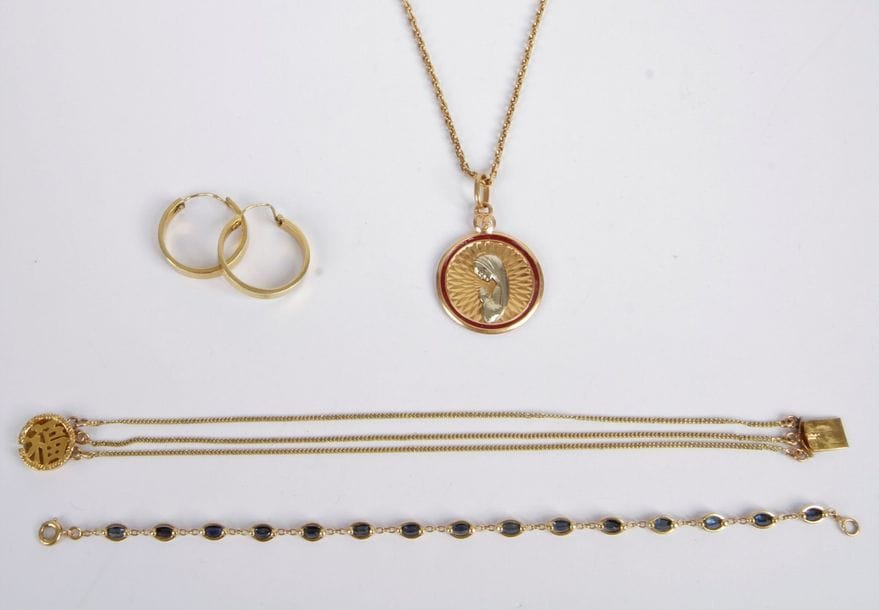 Lot de bijoux en or 18K (750) comprenant: une chaîne retenant une médaille de baptême en pampille, un bracelet orné de pierres bleues, un bracelet agrémenté d'un idéogramme et une paire de créoles. Poids brut: 34 g