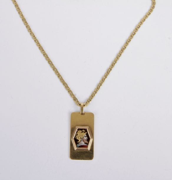 Chaîne en or 18K (750), retenant un pendentif en or 18K orné d'une miniature émaillée polychrome figurant une divinité casquée. Poids brut: 39,3 g