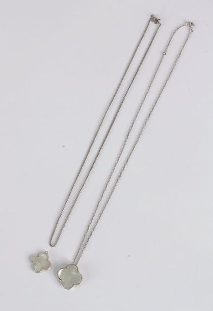 Chaîne en or gris 18K (750) retenant un pendentif en or gris dessinant un trèfle orné de nacre. Poids brut: 6,7 g (on joint une chaîne et un pendentif en argent en forme de trèfle)
