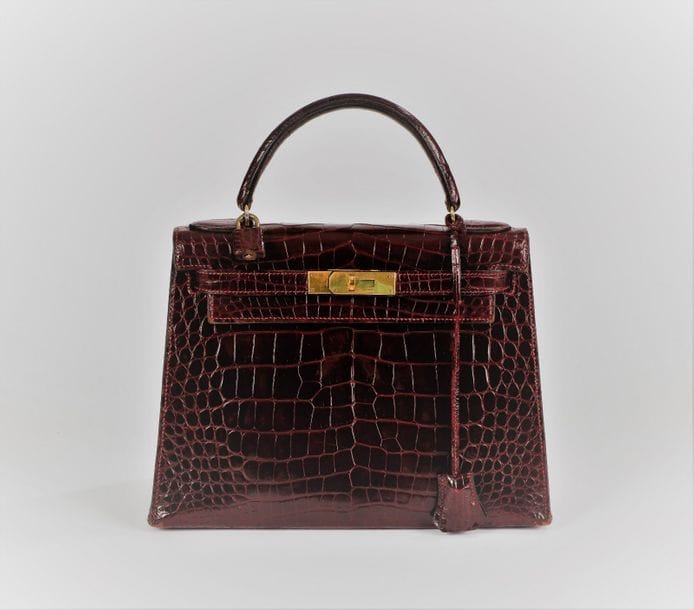 Hermès. Paris Made in France. 1981
Sac à main " Kelly " en crocodile d'estuaire ( crocodiles dororus) de couleur bordeaux. Complet avec sa clef et son cadenas. Petit bijouterie en métal plaqué or.  
28 x 23 x 13,5 cm 
Bel état général, sauf légères traces sur le devant et aux coins.