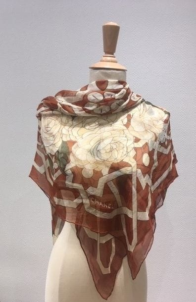 Chanel
Grand carré en mousseline de soie, imprimé d'un motif de camélias. 120 x 120 cm