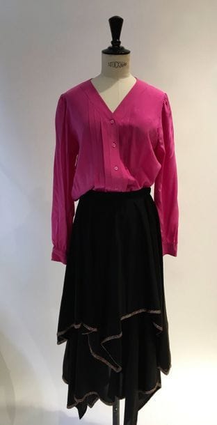 Yves Saint Laurent Rive Gauche. 
1 chemisier de soie fuchsia sans col, (petites tâches), orné sur le devant de plis plats.T36. 
On y joint une jupe longue noire à panneaux asymétriques bordée d'un galon en lurex multicolore.
