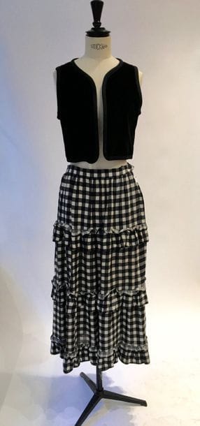 Yves Saint Laurent Rive Gauche
Gilet court sans manche en velours noir  gansé d'un galon tressé T40 (I). 
On y joint une jupe à volants, longue et à carreaux.  T42 (tâches)