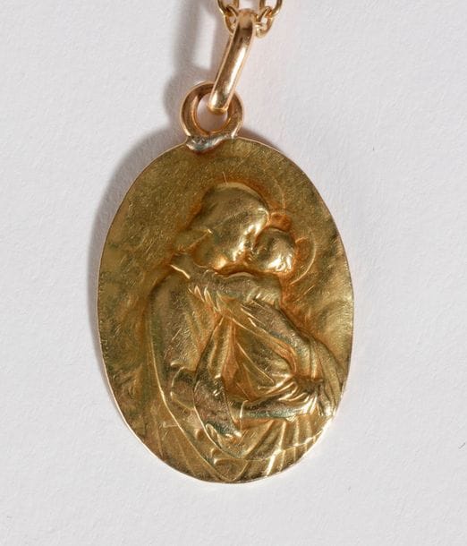 Fine chaîne en or 18K (750) retenant en pampille une médaille en or 18K. Poids: 7,9 g