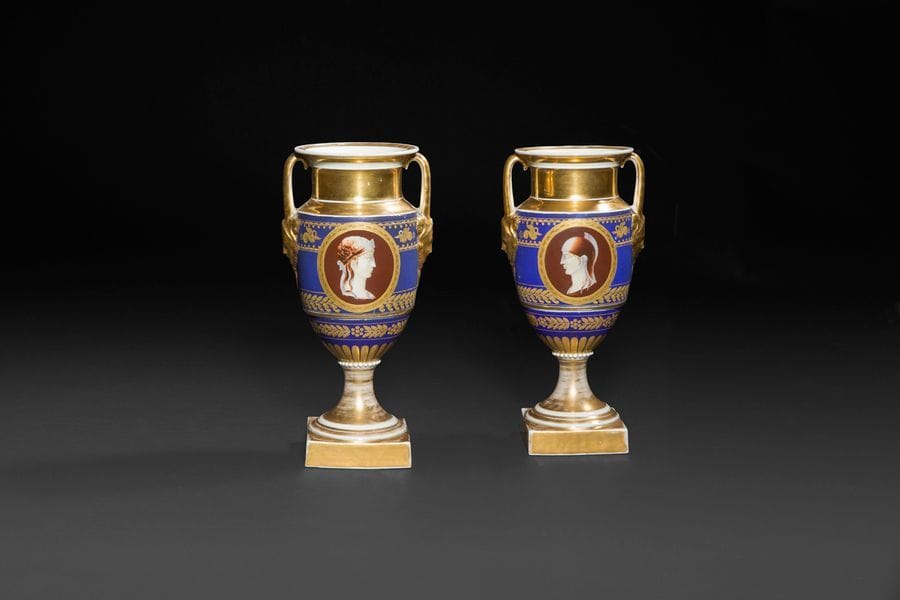 Paris
Paire de vases en porcelaine de forme balustre à fond bleu et or à décor de profils antiques façon camée dans des médaillons à fond brun et au revers, d’amours dans des médaillons à fond or.
H : 26,5 cm, un petit éclat avec usures d’or.
