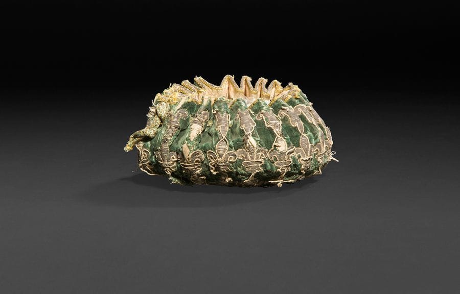 FRANCE XVIIIe siècle
Bourse de jetons en velours vert brodée de fils d’argent complète de sa peau, figurant des fleurs de lys.
Accidents aux cordons, manque un pompon, usures aux fils d’argent.