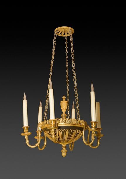 Lustre en bronze patiné et doré à six lumières à décor de bustes de femme, palmes et palmettes, surmonté d’une amphore ; (percé pour l’électricité).
Fin du XVIIIe siècle - début du XIXe siècle.
H : 84 cm, D : 56 cm