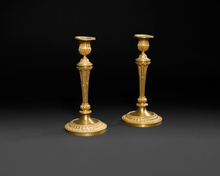 Paire de flambeaux en bronze doré, le fût cannelé reposant sur une base circulaire à frise de feuillages et frise de perles.
Style Louis XVI, XIXe siècle.
H : 24,5 cm