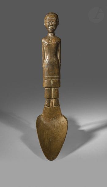 Une cuillère au manche sculpté d’un personnage en habit traditionnel.
Madagascar
Bois, patine d’usage, deux percements à l’arrière
H. : 24 ,5cm