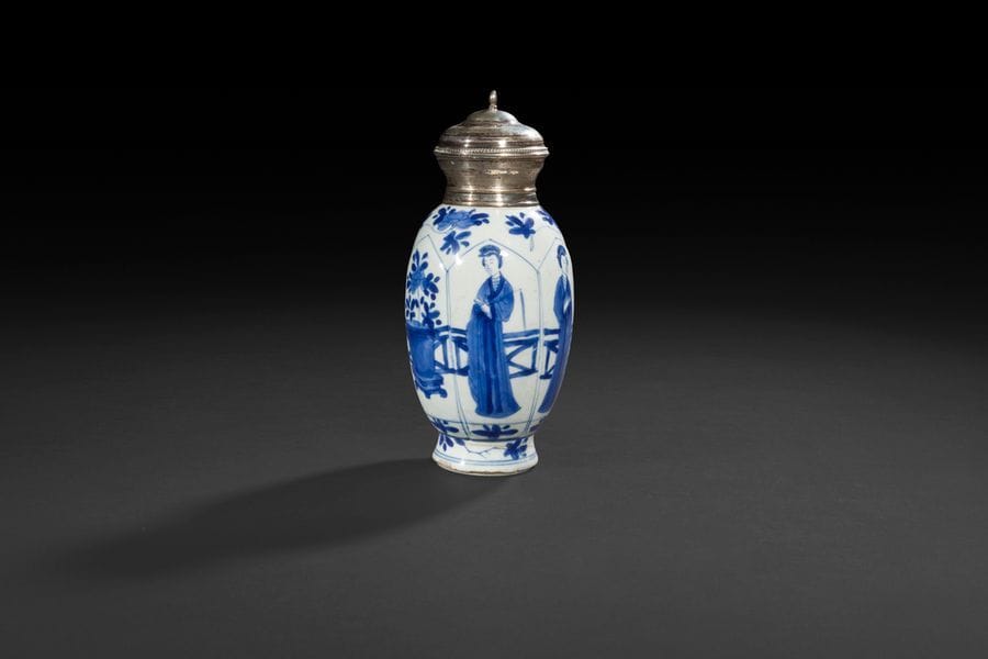 
Chine
Vase oblong en porcelaine à décor en bleu sous couverte de femmes chinoises et de jardinières dans des réserves en forme de pétales, fleurs et feuillage sur l’épaulement et la base.
Époque Kanghi (1662-1722).
H : 19 cm
Col et bouchon en argent européen.
Fêlure sur la base.