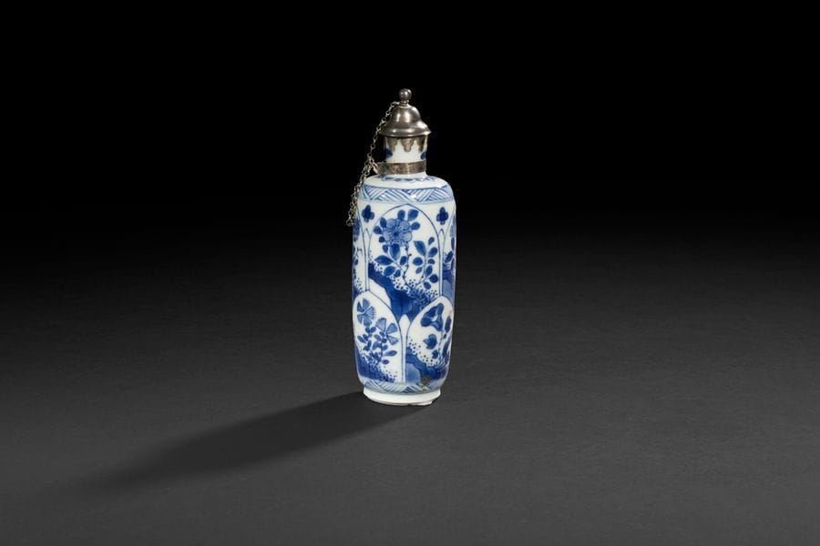 
Chine
Petit flacon cylindrique en porcelaine à décor en bleu sous couverte de fleurs dans des réserves en forme de pétale.
Marqué à la feuille.
Époque Kanghi (1662-1722). 
H : 14,3 cm
Col et bouchon en argent européen.