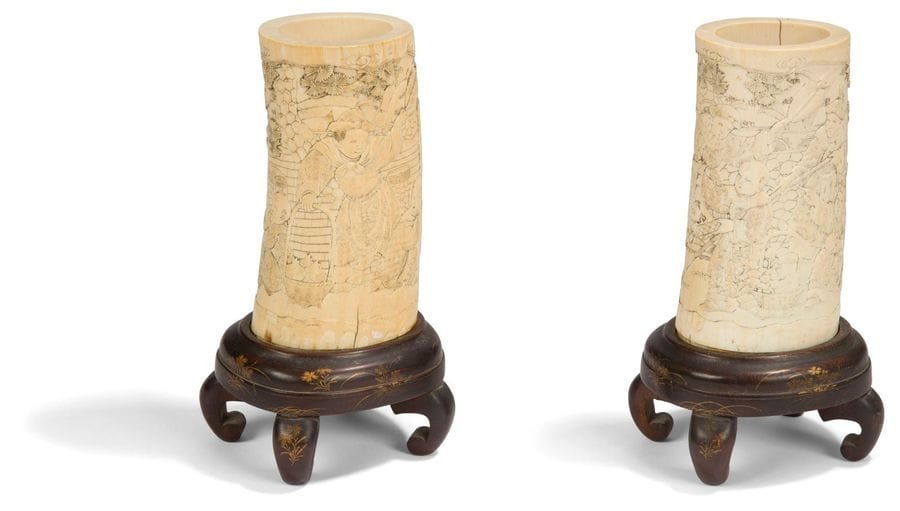 JAPON - Époque MEIJI (1868 - 1912) Paire de vases en ivoire sculpté à décor sous les pins, d enfants regardant des peintures en rouleau, encadrés par leur professeurs, des grenades et des fleurs dans des paniers à leurs pieds. H : 13,9 cm (manque le fond,
