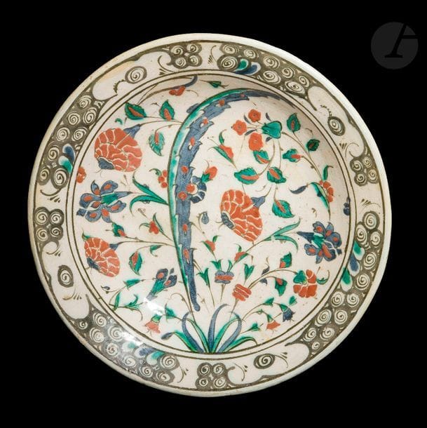 Plat tabak à décor floral, Turquie ottomane, Iznik, XVIIe siècle
Céramique siliceuse à décor peint en polychromie sous glaçure transparente incolore. Au centre, bouquet de roses, églantines et iris équilibré par une feuille saz. Sur le marli, frise de vagues et rochers noirs stylisés.
Diamètre : 30,5 cm
État : plusieurs restaurations.

An Iznik fritware dish, Ottoman Turkey, Iznik, 17th century


Ancienne collection de Madame A.O. (lots 56 et de 78 à 125)